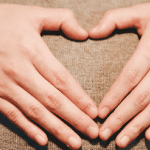 Can circumcision hurt my baby. mother holding handsin heart shape over baby bump