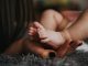 female hand holding a baby foot illustrating parent care and consent